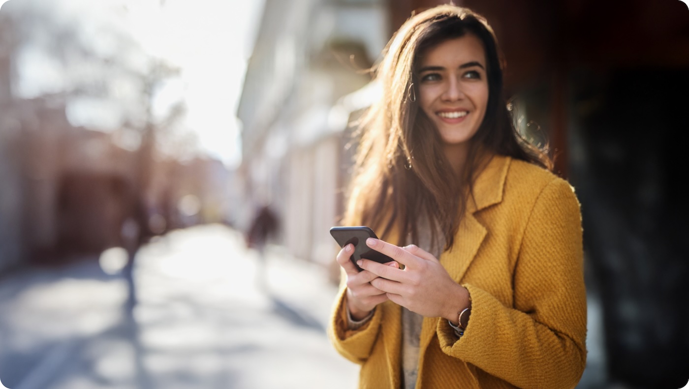 Glückliche Frau mit Smartphone in der Hand